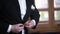 Man buttoning on a black jacket. Wedding details - elegant groom dressed wedding tuxedo costume is waiting for the bride