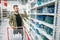 Man buying shovel in supermarket, tools department