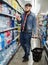 man buying still water in grocery section