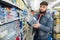 man buying still water in grocery section