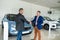 man buys an expensive car representative of car dealership shakes his hand as sign of agreement