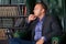 The man, calm and confident businessman sitting in a chair, library