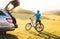 Man came by auto in mountain with his bicycle take it off and staying and enjoying landscape. Mountain biking concept image