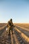 Man in camouflage with a metal detector and shovel walks across the field in search of ancient values, in the summer