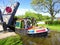 Man on canal narrowboat passing under lift bridge