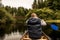Man canoeing with Canoe on the lake of two rivers in the algonquin national park in Ontario Canada on cloudy day