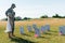 Man in cap and kid in straw hat looking at headstones in graveyard