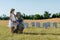 Man in cap sitting near kid in straw hat and headstones in graveyard