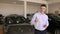 Man in a car dealership near a new car with keys, he shows a thumbs up.