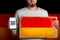 A man with a cardboard and a phone in his hand. The Flag Of Germany. Concept of freedoms and human rights. Copy space