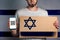 A man with a cardboard and a phone in his hand. The Flag Of Israel. Concept of freedoms and human rights. Copy space