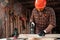 A man carpenter cuts a wooden beam using an electric jigsaw, male hands with an electric jigsaw closeup. Work with wood