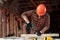 A man carpenter twists a screw into a tree with an electric screwdriver, male hands with a screwdriver close-up. Work with wood