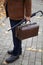 Man with carpetbag in jacket stands in alley of autumn park