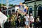 Man carries big colorful group flag by city street full of people at dominican carnival