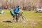 A man carries a child in a child`s seat on a bicycle to the opening of a bike season in the city park on a spring sunny day