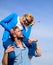 Man carries girlfriend on shoulders, sky background. Woman enjoy perfect romantic date. Couple happy date having fun