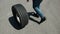 Man carries one tire, in area where there are a lot of sports racing cars