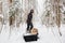 A man carries a pile of firewood in the winter forest