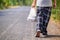 Man carry many grocery plastic bags while walking along the road