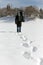 Man carry a sledge in the deep snow, footprints in the front