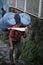 Man Carry Two Big Gallons on His Headon The Side of Tenzingâ€“Hillary Airport Runaway, Lukla Nepal