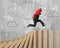 Man carrying arrow up running on falling wooden dominos