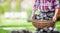 Man carrying basket full of coal briquettes in the backyard of his house