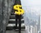 Man carrying golden dollar sign climbing old concrete stairs