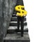 Man carrying golden dollar sign climbing old concrete stairs