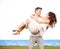 Man Carrying His Girlfriend in a Windy Beach