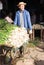 Man carrying wheelbarrow with green onions during harvest