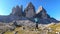 Man carrying woman piggyback with the close up view on the Tre Cime di Lavaredo (Drei Zinnen) in Italian Dolomites.