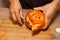 A man carves eyes and a mouth in a pumpkin for Halloween.