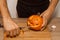 A man carves eyes and a mouth in a pumpkin for Halloween.