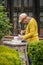 Man carving a stone during an outdoor sculpture lesson or class in the botanical garden