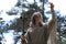 A man in a cassock spends a ritual in a dark forest