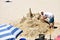 Man and castle made of sand at Silgar Beach. Sanxenxo, Spain. 