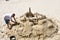 Man and castle made of sand at Silgar Beach. Sanxenxo, Spain. 