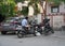 A Man casually sitting on his motorcycle and looking at phone outside a building. : Udaipur India - August 2020