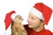 Man and cat in Santa\'s hat looking at each other