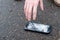 Man catching broken smartphone from the ground. Damaged mobile phone with cracked touch screen