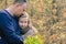 Man caucasian dad hugs beautiful daughter on background of colorful autumn trees. Family weekend. Relaxing outdoor