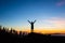 Man celebrating sunset with arms outstretched in mountains