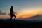 Man celebrating sunset looking at view in mountains