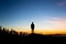 Man celebrating sunset looking at view in mountains