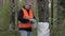 Man with cell phone and bag of plastic bottles in forest