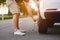 The man changes the tire on his car at sunset