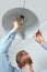 Man changing light bulb in pendant lamp indoors