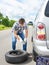 Man changing a spare tire of car